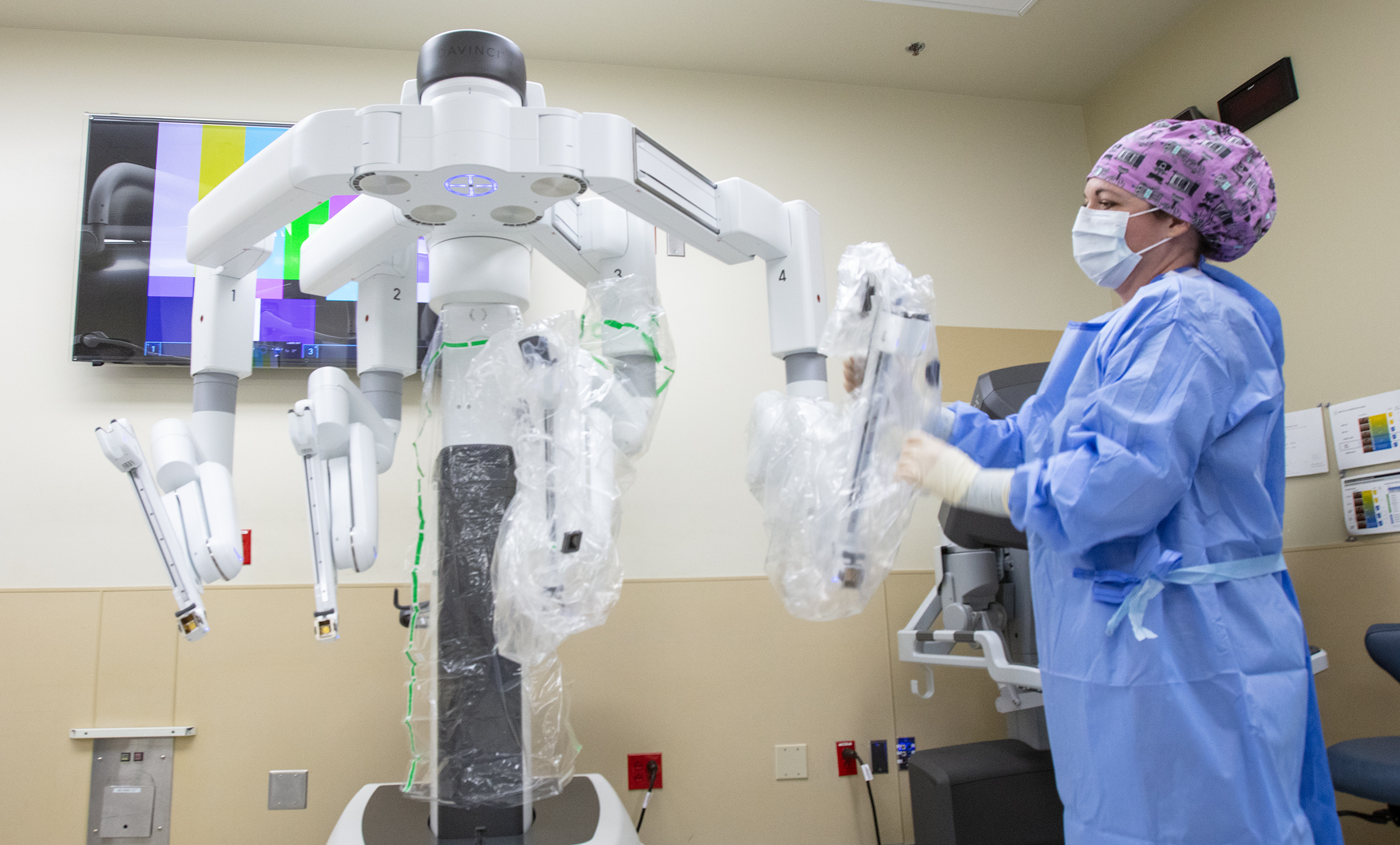 Surgical team member preparing the da Vinci Xi robotic system for a procedure